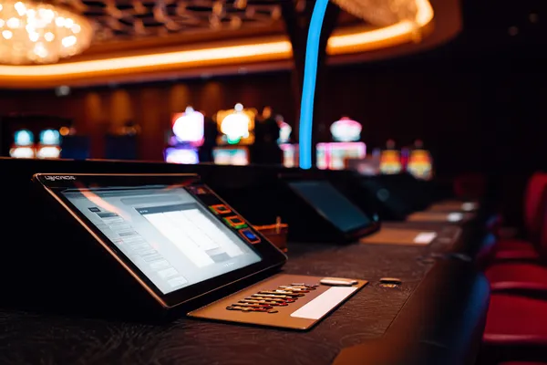 Um homem comemorando uma vitória em seu laptop enquanto símbolos de jogos flutuam ao redor, capturando a emoção dos jogos 63V.